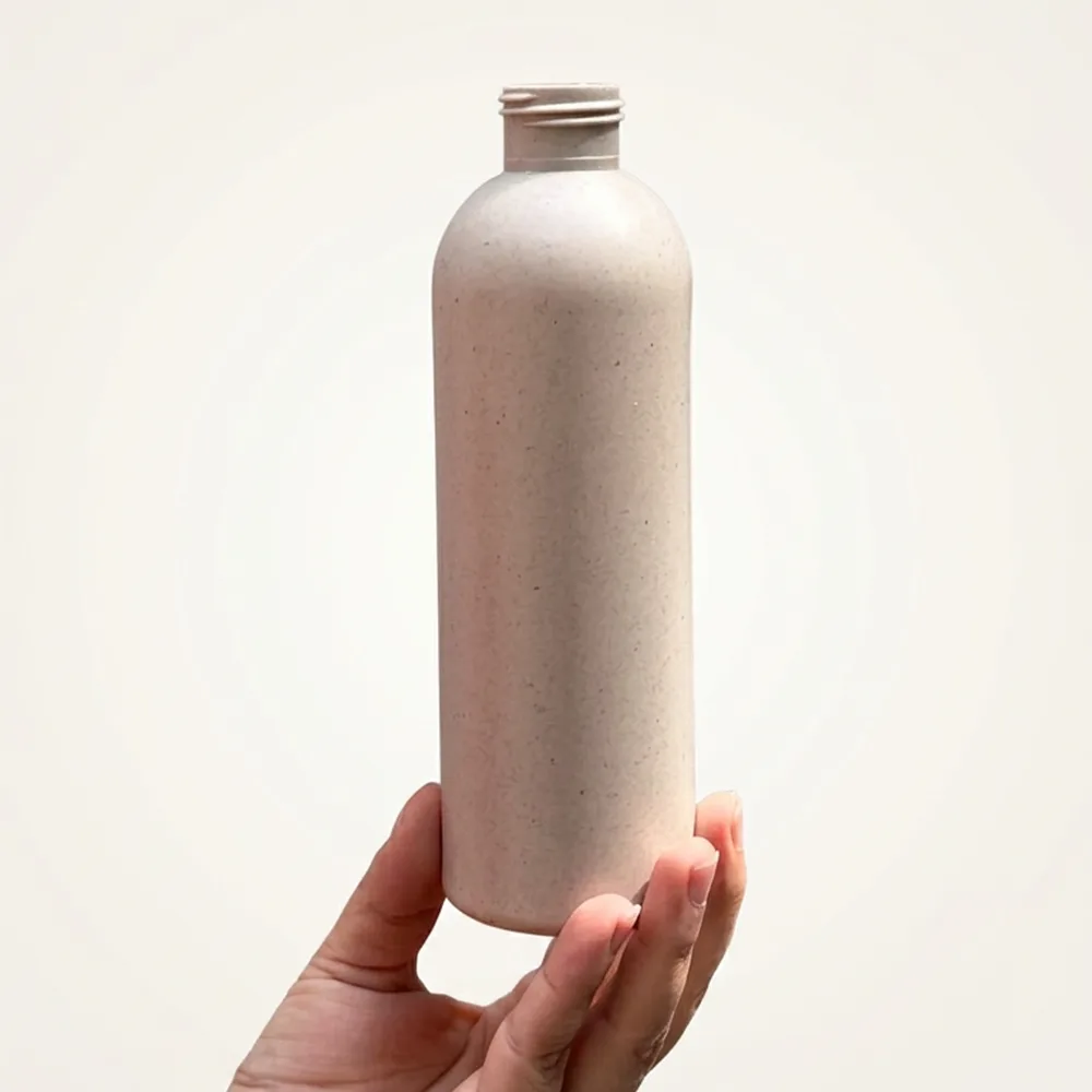 Blush pink bamboo biopolymer bottle held in hand